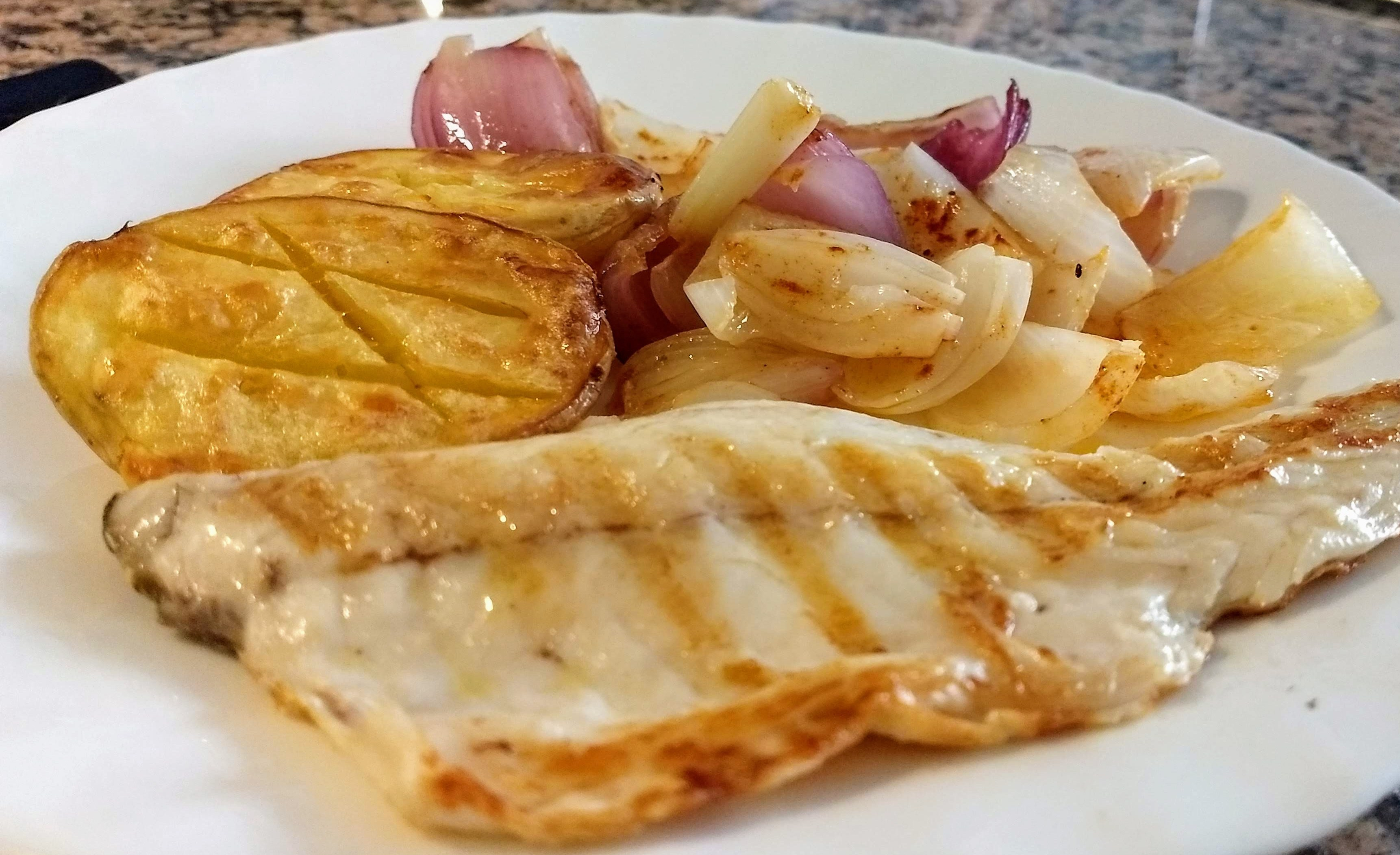 Lubina a la plancha con cebollas y patatas al horno